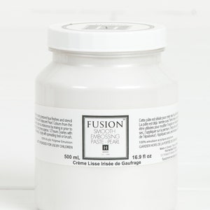 May include: A white plastic jar of Fusion Smooth Embossing Paste - Pearl. The jar is labeled with the product name, size (500 mL / 16.9 fl oz), and instructions for use. The jar is sitting on a white surface.