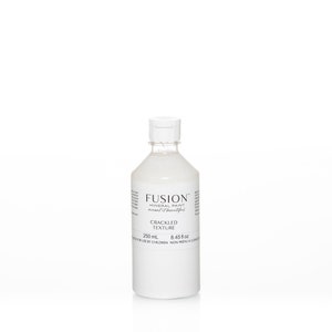 May include: A white bottle of Fusion Mineral Paint Cracked Texture. The bottle is 250 ml or 8.45 fl oz. The bottle is on a white surface.