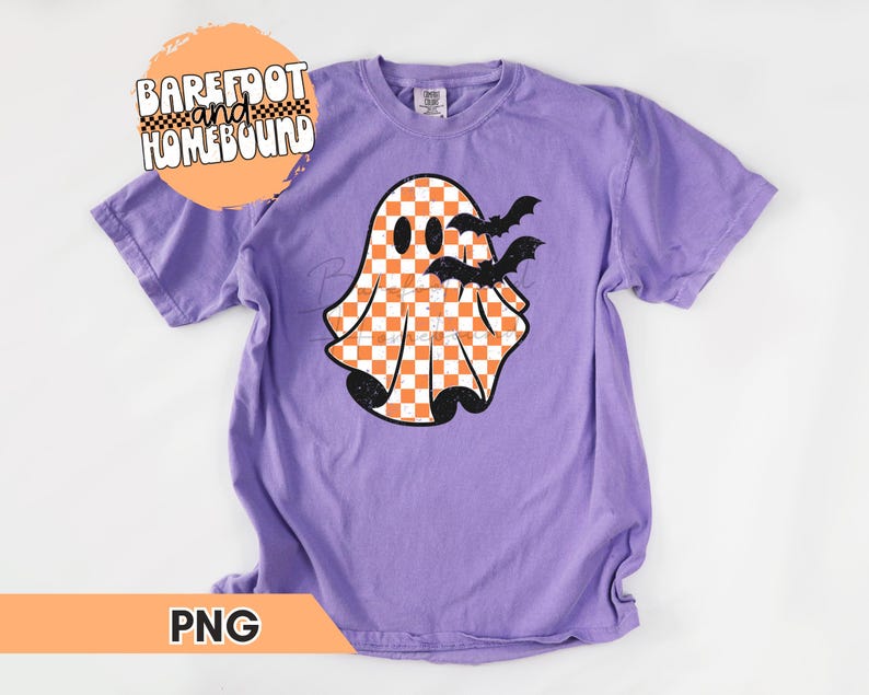 以下が含まれることがあります： 紫色のTシャツに、オレンジと白のチェック柄の白い幽霊と、その周りを飛ぶ黒いコウモリが描かれています。画像の左上隅には「Barefoot and Homebound」というテキストがあります。
