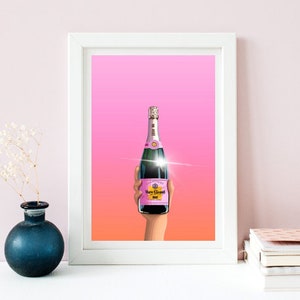 May include: A pink champagne bottle with a gold label that says "Veuve Clicquot" is held up in a hand against a pink and orange gradient background.