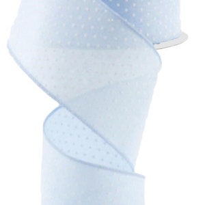 May include: A roll of light blue ribbon with white polka dots. The ribbon is curled and ready to be used for crafting or decorating.