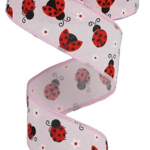 May include: Pink ribbon with a white background and a repeating pattern of red ladybugs with black spots and white flowers.