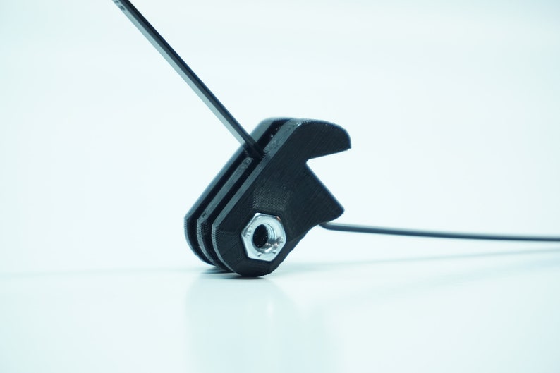 May include: A black plastic camera mount with a silver screw. The mount has a threaded hole for attaching a camera or other accessory.