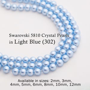 Op de afbeelding: Close-up van lichtblauwe Swarovski 5810 kristallen parels. De afbeelding toont meerdere strengen van de parels, met de tekst "Swarovski 5810 Crystal Pearls in Light Blue (302)". Verkrijgbaar in maten van 2 mm tot 12 mm.