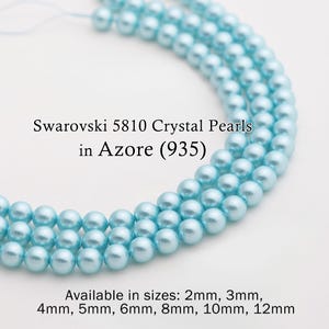 May include: Close-up of strands of light blue Swarovski 5810 Crystal Pearls in Azore (935). Available in sizes from 2mm to 12mm. The pearls are round and have a glossy finish. The image is on a white background.
