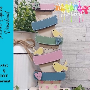 May include: A stack of decorative wooden planters in pastel colours, each with a label and a small bird cutout. The planters are arranged vertically, with the text "Instant Digital Download" and "SVG & DXF Format" visible.