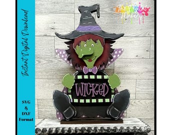 May include: A wooden Halloween decoration of a seated witch with a green face, red hair, and a black hat with purple accents. The witch holds a sign that says "WICKED". The image also includes the text "Instant Digital Download" and "SVG & DXF Format".