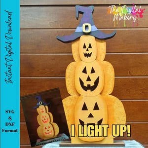May include: A wooden Halloween decoration featuring three stacked pumpkins with carved faces. The top pumpkin wears a purple witch hat. The text "I LIGHT UP!" is displayed at the bottom. The image also includes a smaller version of the decoration.