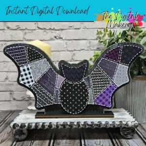 May include: A decorative bat with patchwork wings in shades of black, gray, and purple, resting on a distressed white wooden stand. The bat has a black body and is embellished with white stitching. The text "Instant Digital Download" is visible.