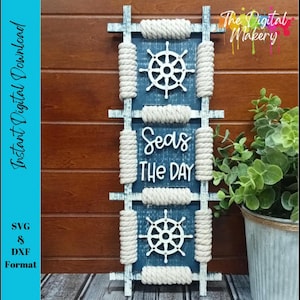 May include: A nautical-themed wall hanging with a blue background and white accents. It features two ship wheels and the phrase "Seas the Day" in white script. The design includes rope detailing and is framed with light blue wood.