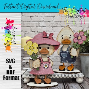 May include: Wooden duck figurines, one wearing a pink hat and dress, the other in denim overalls, each holding a flower. The text "Instant Digital Download" and "The Digital Makery" are visible. The figurines are on a white tiered stand.