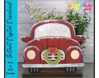 May include: Red vintage truck with a wreath and a bow, carrying a Christmas tree. The truck is decorated with white snow and has a wooden base.