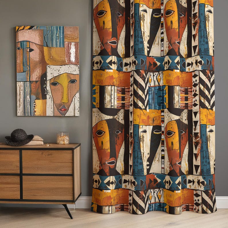 May include: A rectangular wall art piece and a floor-length curtain featuring a repeating pattern of stylized faces in shades of orange, yellow, black, and blue, accented with geometric shapes, stripes, and triangles on a textured fabric surface.