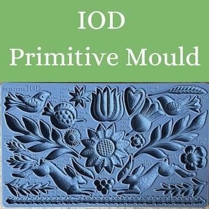 May include: A blue silicone Primitive Mould with various embossed designs, including birds, flowers, leaves, and rabbits. The text "IOD Primitive Mould" is at the top. Measurements are in milliliters and grams.