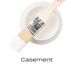 Può includere: Un campione di vernice bianca con un pennello immerso nella vernice. La vernice è etichettata "Fusion Mineral Paint" e il colore è "Casement".