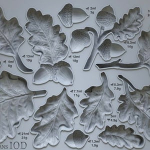 May include: A collection of gray oak leaf and acorn molds, with varying sizes and weights indicated in milliliters and grams. The image includes the text "OAK LEAVES & ACORNS IOD".
