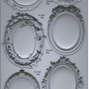 May include: A collection of six oval-shaped vintage brooch molds in a light gray color. Each mold features intricate floral and decorative designs, with measurements in milliliters and grams. The text "VINTAGE BROOCHES IOD" is at the bottom.
