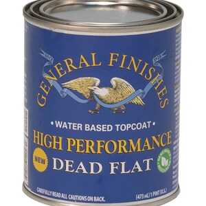 May include: A blue can of General Finishes High Performance Dead Flat water-based topcoat. The can has a gold eagle logo and the text "Since 1928" on it. The can is labeled "New" and has a green leaf logo that says "Renewable Resources". The can is 473 ml or 1 pint.
