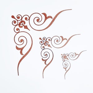 May include: Four decorative corner designs in varying sizes. Each corner features a swirling, ornate pattern in a warm brown color. The designs are set against a white background, highlighting the intricate details.