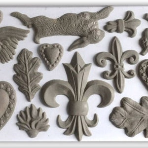 May include: A set of 16 grey clay molds featuring various designs, including hearts, leaves, a rooster, a rabbit, a fleur-de-lis, and acorns.