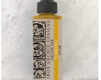 May include: A 2 fl oz bottle of Iron Orchid Designs Decor Ink in the color Turmeric. The bottle is yellow with a black label featuring a decorative design and the brand name.
