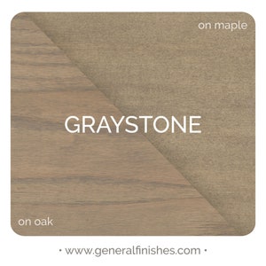 May include: Graystone wood stain color sample on oak and maple wood. The sample shows the color on two different types of wood.