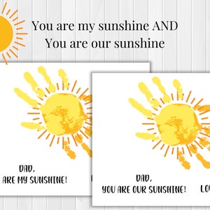 May include: Two cards with handprint sun designs and the text "Dad, you are my sunshine!" and "Dad, you are our sunshine! Love,"