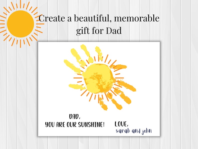 May include: A white card with a yellow sun made from handprints. The text on the card reads "Dad, You are our sunshine! Love, Sarah and John."