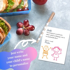K&ouml;nnte beinhalten: Eine wei&szlig;e Karte mit einer handschriftlichen Nachricht, die lautet: "Jack, Waving at you from afar and wishing you a wonderful day! I love you! Mom". Auf der Karte befinden sich zwei Strichm&auml;nnchen, ein Junge und ein M&auml;dchen. Die Karte liegt auf einer grauen Oberfl&auml;che mit einer Lunchbox, Trauben und einem Stift.