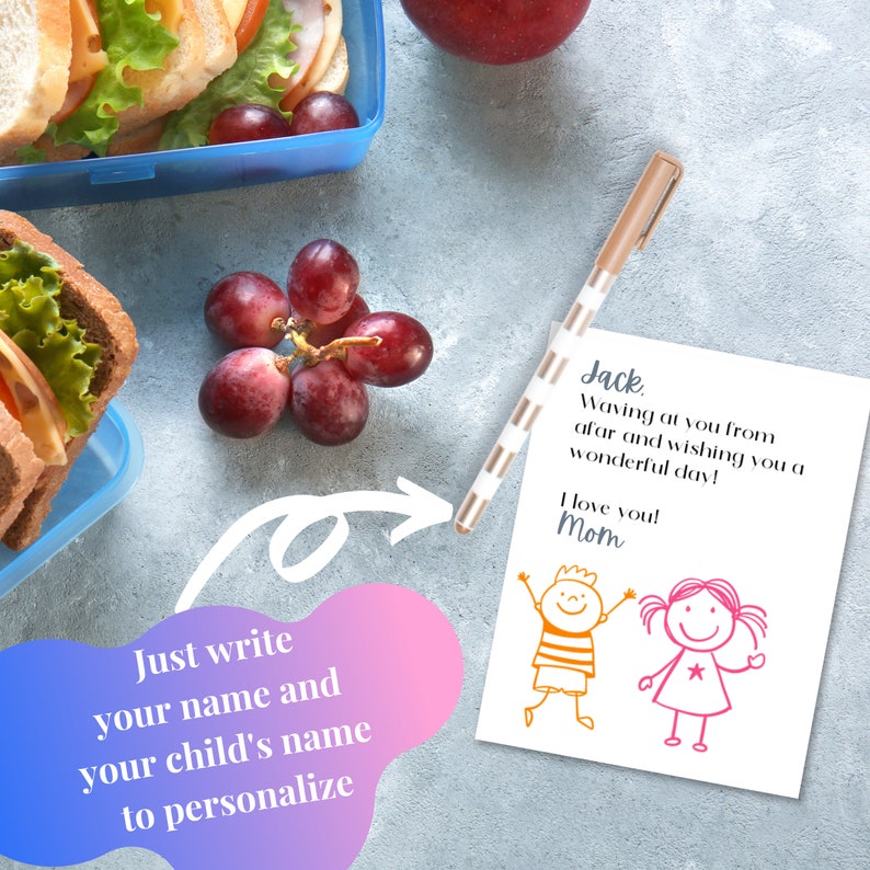 K&ouml;nnte beinhalten: Eine wei&szlig;e Karte mit einer handschriftlichen Nachricht, die lautet: "Jack, Waving at you from afar and wishing you a wonderful day! I love you! Mom". Auf der Karte befinden sich zwei Strichm&auml;nnchen, ein Junge und ein M&auml;dchen. Die Karte liegt auf einer grauen Oberfl&auml;che mit einer Lunchbox, Trauben und einem Stift.