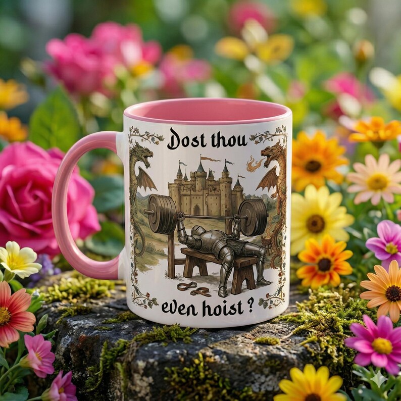 May include: A white ceramic mug with a pink interior and handle. The mug features a medieval-themed illustration of a knight lifting weights, with the text "Dost thou even hoist?" in a decorative font. The background is a garden.