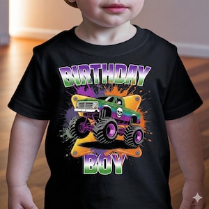 May include: Black t-shirt with a colourful monster truck design and the text "BIRTHDAY BOY". The truck is green, purple, and yellow, with large black tyres and a skull graphic. The text is in white and green.