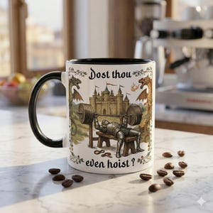 May include: White ceramic mug with a black interior and handle, featuring a medieval knight lifting weights with the text "Dost thou even hoist?" and a castle and dragon design. Coffee beans are scattered around the mug.