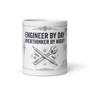 Op de afbeelding: Witte keramische mok met de tekst "ENGINEER BY DAY OVERTHINKER BY NIGHT" in het zwart. De mok heeft een ontwerp met potlood, moersleutel en bouten. Een perfect cadeau voor ingenieurs.