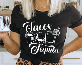 Może przedstawiać: Czarny T-shirt z białym napisem "Tacos and Tequila". Tekst jest w stylizowanym kroju pisma. Koszulkę nosi osoba z blond włosami.