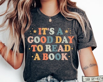 May include: A dark grey heather t-shirt with the text "It's a good day to read a book." in colorful retro lettering.