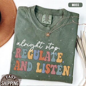 May include: A green t-shirt with the text "alright stop REGULATE AND LISTEN." in colorful, retro-style lettering.