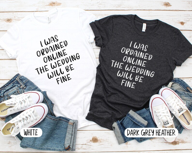 May include: Two t-shirts with the text "I was ordained online the wedding will be fine" in black lettering on a white t-shirt and a dark grey heather t-shirt.