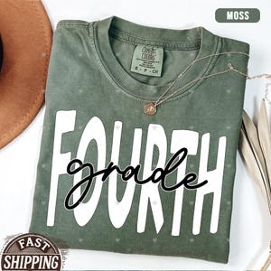 Op de afbeelding: Een mosgroen T-shirt met de tekst "FOURTH grade" in witte letters. Het shirt heeft een verweerde look en is gemaakt van een zachte, comfortabele stof.
