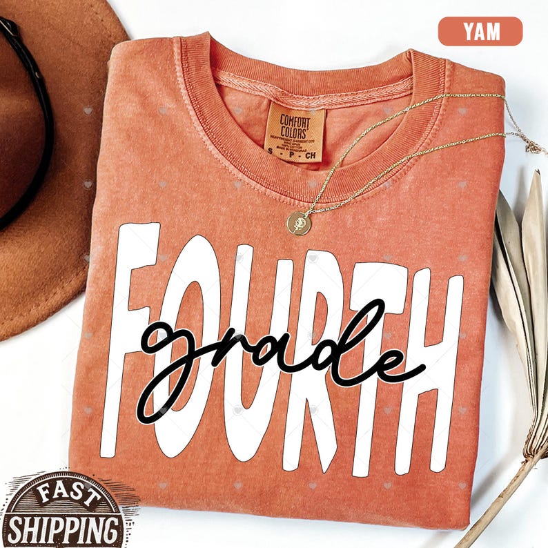 Op de afbeelding: Een koraal gekleurd T-shirt met de woorden "FOURTH grade" in witte en zwarte letters.
