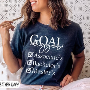 May include: Heather navy blue t-shirt with white text that reads "GOAL digger" and a checklist with the following items: Associate's, Bachelor's, Master's.