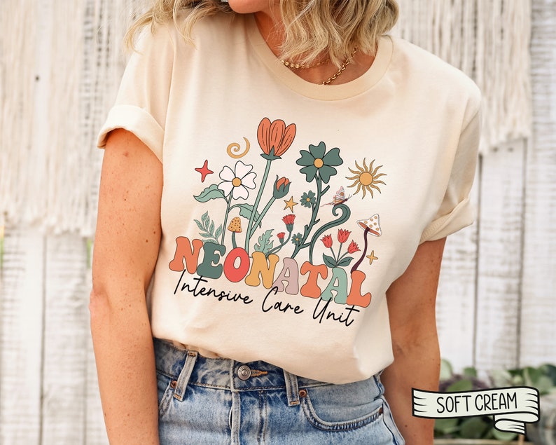 May include: A cream colored t-shirt with a retro floral design and the text "Neonatal Intensive Care Unit".