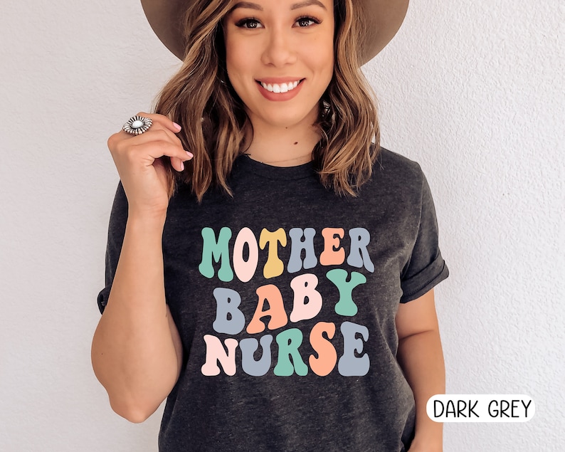 Może przedstawiać: Ciemnoszary T-shirt z napisem "MOTHER BABY NURSE" w kolorowych retro literach.