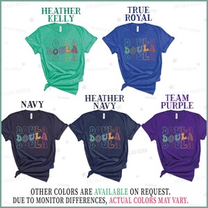 May include: Five t-shirts in different colors with the word "Doula" repeated three times in a retro font. The colors are heather kelly, true royal, navy, heather navy, and team purple.