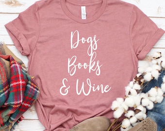May include: A dusty rose colored t-shirt with the text "Dogs Books & Wine" in white lettering.