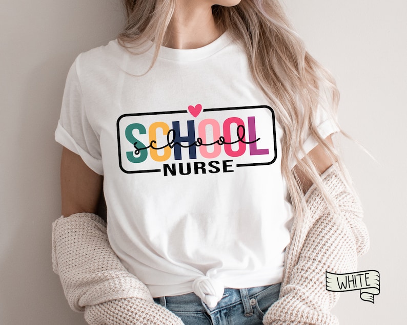 May include: White t-shirt with a colorful graphic that says "SCHOOL NURSE" with a pink heart above the text.