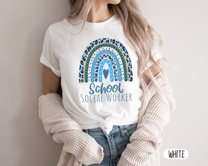 Puede incluir: Camiseta blanca con un dise&ntilde;o de arco&iacute;ris azul y verde y el texto "School Social Worker".