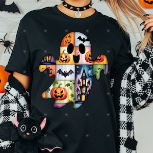 May include: Black t-shirt featuring a patchwork ghost design with Halloween-themed squares. The ghost includes jack-o'-lanterns, bats, and a haunted house. The design is colorful and stitched, perfect for the spooky season.
