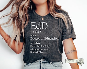 Puede incluir: Camiseta gris oscuro jaspeado con el texto "EdD" y la definición "Doctor en Educación". El texto adicional incluye "Experto en resolución de problemas", "Innovador en educación" y "Maestro de investigación".