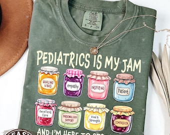May include: Green t-shirt with the text "Pediatrics is my jam" and a row of eight jars of jam, each with a different label, such as "Healing Vibes", "Empathy", "Inspiring", "Patient", "Excellent Care", "Personalized Support", "Kind & Strength", and "Compassion". The text "And I'm here to spread it!" is below the jars.